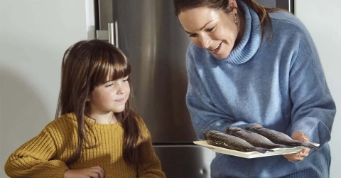 Acuicultura de España - Mujer y niña con plato de pescado