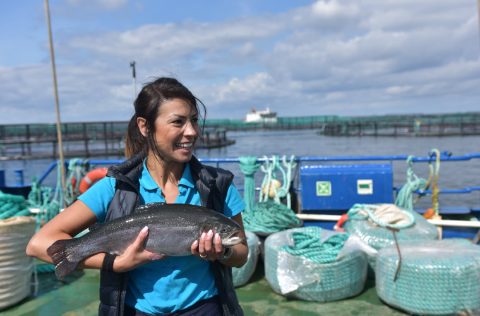 BioMar, bióloga sujeta pescado en granja