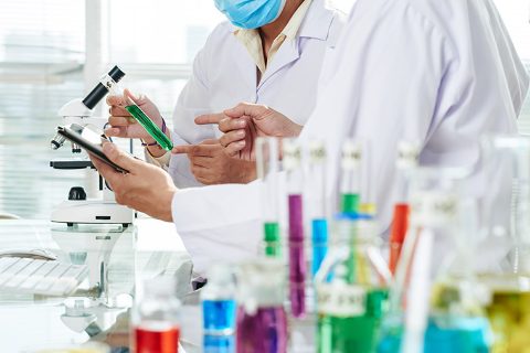 Científicos analizan probeta verde laboratorio
