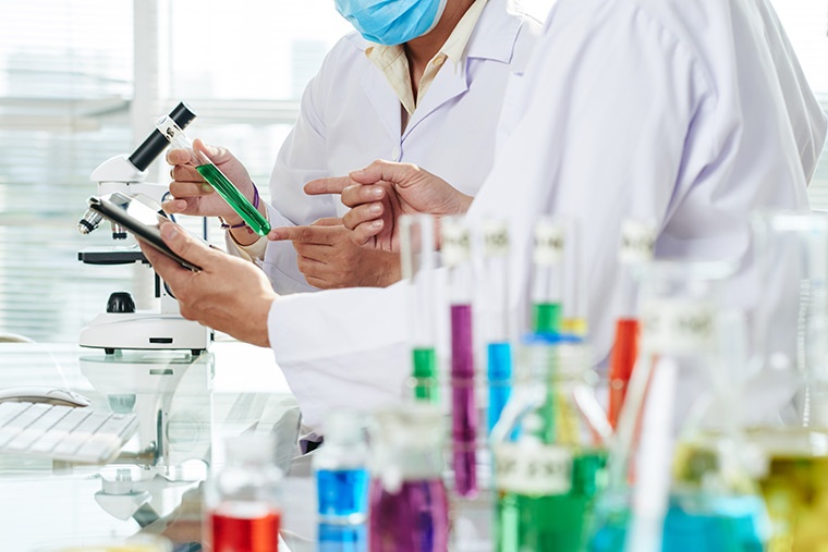 Científicos analizan probeta verde laboratorio Científicos analizan probeta verde laboratorio