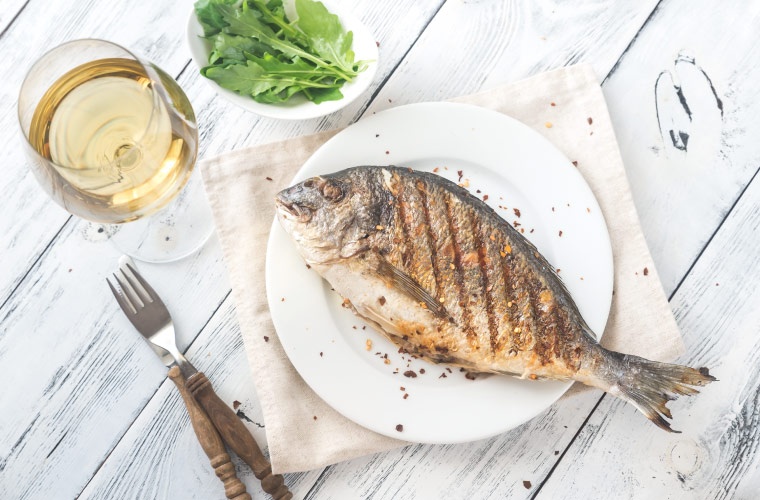 Dorada a la parrilla en una mesa Dorada a la parrilla en una mesa
