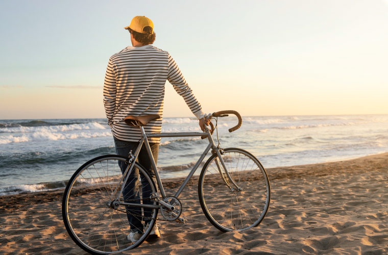 Hombre con bicicleta mirando el mar