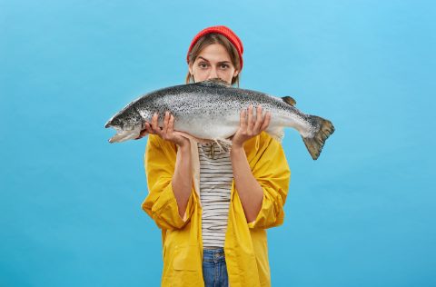 Mujer sostiene salmón Atlántico