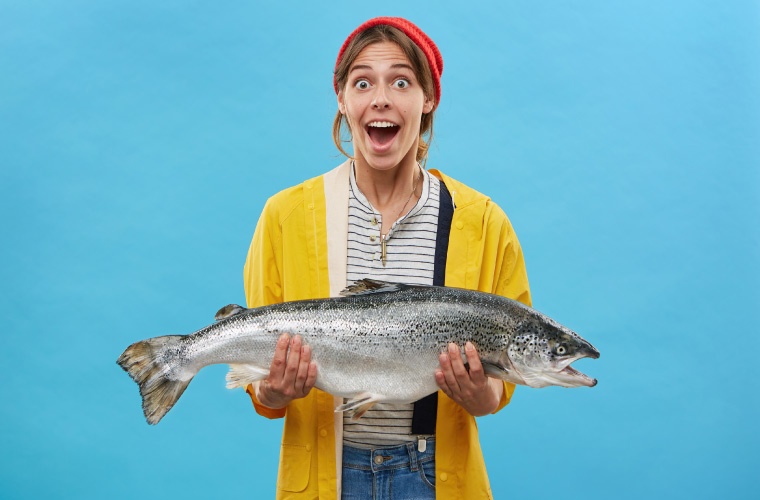 Mujer sostiene salmón Atlántico Mujer sostiene salmón Atlántico