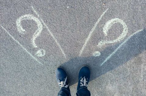 Pies de mujer delante de dos signos de interrogación. El dilema