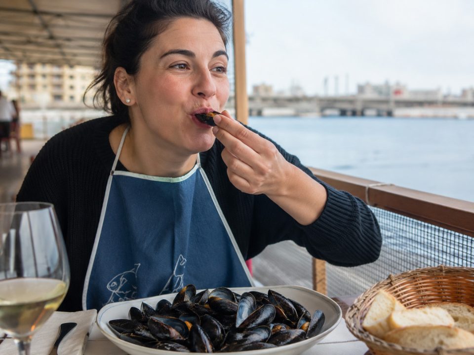 Donna mangiando cozze tarantine