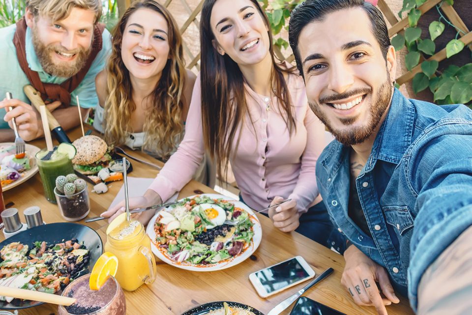 Jovenes haciendo un selfie en mesa con comida