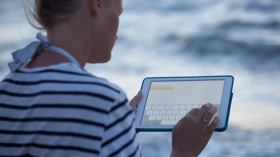 Mujer con ipad frente al mar