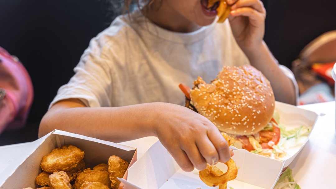 Niña come hamburguesa